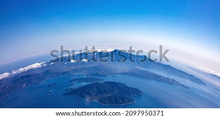Planet Earth Curvature. Aerial shot. Blue sky and clouds over island in the ocean. Space, science concept