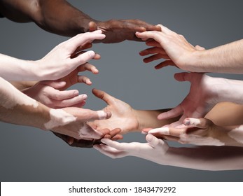 Planet Earth. Hands of different people in touch isolated on grey studio background. Concept of relation, diversity, inclusion, community, togetherness. Weightless touching, creating one unit.