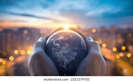Planet Earth in the hands of a man against the background of the lights of the evening city. Concept and symbol on the theme of ecology, earth conservation. Elements of this image furnished by NASA.