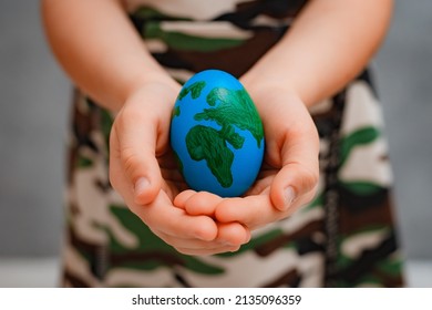 planet Earth in the shape of an egg in children's hands close-up. The concept of global problems of humanity, peace to the world, no war, military, soldier guard