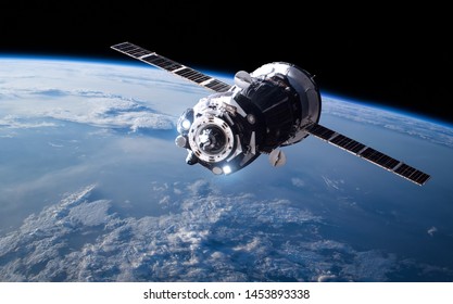 Planet Earth and space craft. Black background. Elements of this image furnished by NASA
