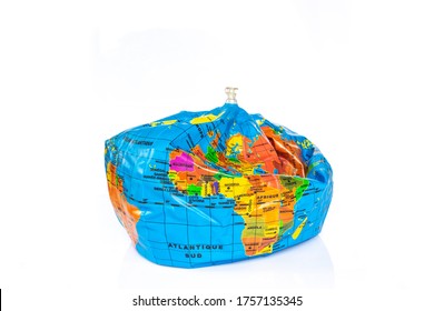Planet Earth Toy Balloon Deflated Isolated On White Background. Earth Overshoot Day, Unsustainable Resources Consumption Concept