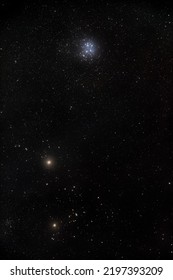 The planet Mars near the Hyades cluster and above them the Pleiades cluster in the night sky.