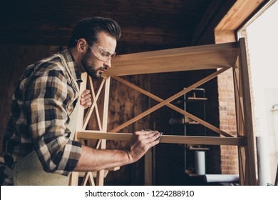 Plank panel wall unit wardrobe storage stand decorative creativity people concept. Low angle close up photo portrait of serious handsome casual skilled gifted repairman handy man using abrasive paper