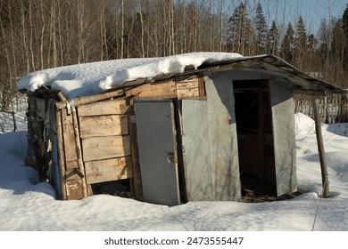 Plank shed. The village in winter. Wooden building. Snow on the roof of the house. - Powered by Shutterstock