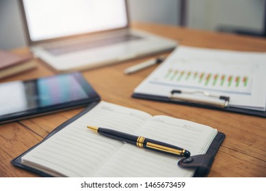 Planner and Agenda Concept. Desktop laptop, tablet and annual report  place on office desk. Notebook and smartphone for Planner to plan timetable, agenda, appointment, organization in meeting room