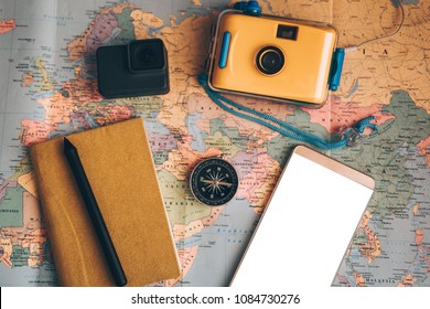 Planner To Do List for trip. Open daily, a compass, pen, camera, gift, phone  and a notebook on the desktop with maps. Close up and Travel Concepts - Powered by Shutterstock