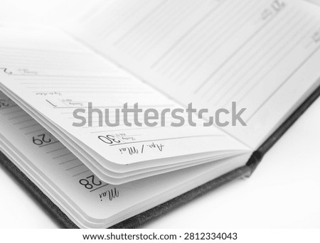 A planner is open and displayed on a flat surface. The pages show spaces for writing tasks and events. The date is written on one of the pages.