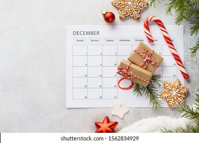 Planner page with Christmas gift boxes, cookies and decoration on light gray background. 25th of December marked with red circle on calendar. Xmas preparation concept. Copy space.