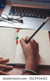 Planner plan Schedule Calendar and reminder agenda, work at home. Man hand planning daily appointment and write business trip in diary book at office desk. 2024 Calendar reminder event concept.