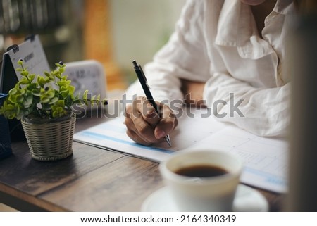 Planner plan Schedule Calendar and reminder agenda, work online at home. Women hand planning daily appointment and write business trip in diary at office desk. 2022 Calendar reminder event concept.