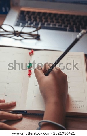 Planner plan Schedule Calendar and reminder agenda, work at home. Man hand planning daily appointment and write business trip in diary book at office desk. 2024 Calendar reminder event concept.