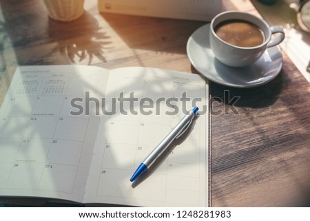 Planner write meeting agenda at Calendar book, work online at home. Diary for organizer to plan timetable, daily appointment, and management job at office desk. Planner book and 2024 Calendar Concept.