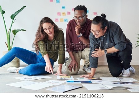 Planning adequately is the first step to achieving success. Full length shot of a group of young businesspeople going over paperwork and ideas at work.