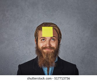 Planning. Close Up Bearded Smiling Business Man Looking Up To The Sticker Stick On His Head Forehead Guessing Trying To Remember What's Wrote On It. 