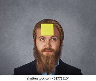 Planning. Close Up Bearded Smiling Business Man Looking Up To The Sticker Stick On His Head Forehead Guessing Trying To Remember What's Wrote On It. 