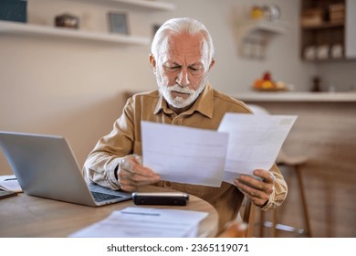 Planning, documents and finance with elderly man on laptop in a kitchen, reading retirement and savings plan in his home. thinking, mortgage and investment paperwork with retired male contemplating. - Powered by Shutterstock