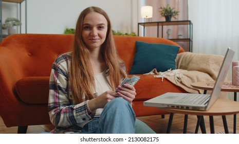 Planning Family Budget. Smiling Happy Young Woman Counting Money Cash, Use Laptop Computer Calculate Domestic Bills At Home. Joyful Girl Satisfied Of Income And Saves Money For Planned Vacation, Gifts