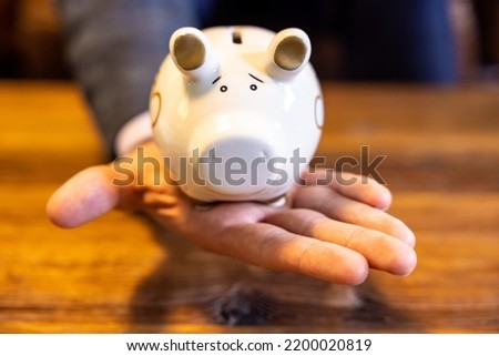 Planning future or economy by saving, investing, calculating. Put coins or money into a piggy bank orsafe. Retirement, TFSA, 401k. Counting debt.