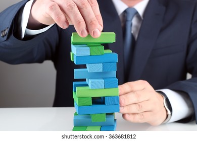 Planning, risk and strategy in business, businessman  putting down  wooden block 