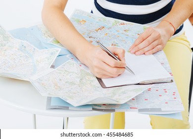 Planning A Trip Using Maps And Taking Notes For The Itinerary