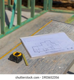 Plans and measuring tape on new home site