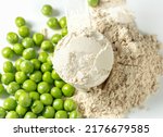 Plant base protein Pea Protein Powder in plastic scoop with fresh green Peas seeds on white Background, isolated copy space. 