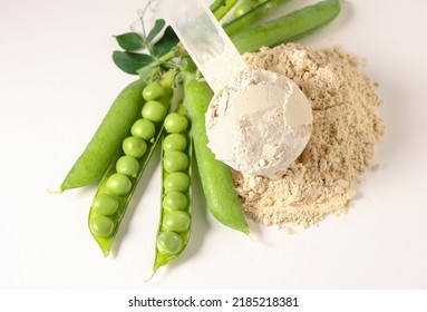 Proteína de base vegetal Pea Protein Polvo en cuchara de plástico con semillas de guisantes verdes frescas sobre fondo blanco, espacio de copia aislado. 