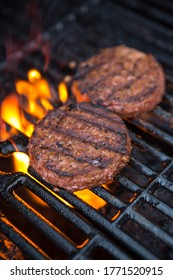 Plant Based Grilled Burger Patty With Grill Marks On A Flaming Grill