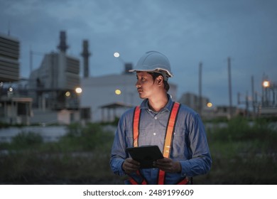 Plant engineers using digital tablet for work with power plant background at the night time, Close up short. - Powered by Shutterstock