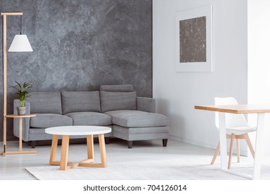 Plant On Wooden Stool And Lamp In Multifunctional Living Room With Coffee Table, Grey Couch And Dining Table