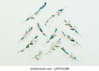 Plant pattern composition. Creative minimalism. Fresh stems on palegreen background.