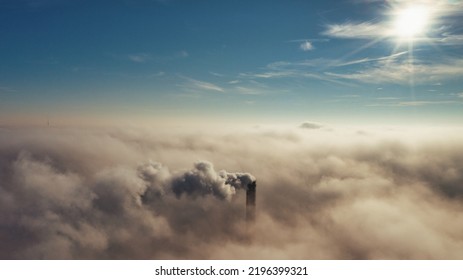 Plant Pipe High Above The Clouds. Harmful Emissions Into The Upper Atmosphere. Climate Change Due To The Combustion Of Carbon Fuel.