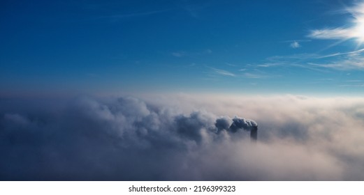 Plant Pipe High Above The Clouds. Harmful Emissions Into The Upper Atmosphere. Climate Change Due To The Combustion Of Carbon Fuel.