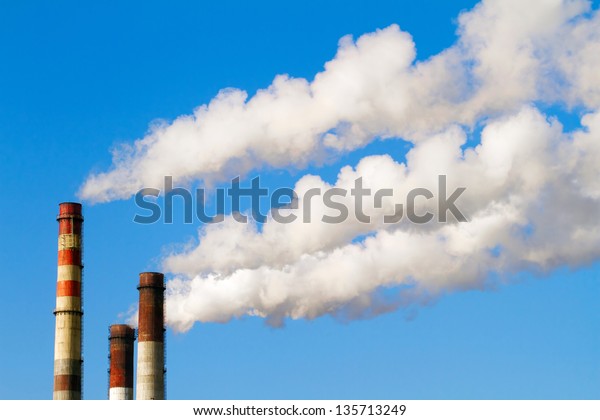 plant pipe with smoke\
against blue sky
