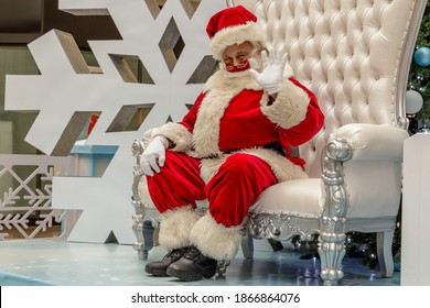 Plantation, Florida, USA - December 3rd, 2020: Visit Westfield Shopping Mall Christmas Santa Claus Wearing A Covid-19 Cloth Face Mask For Personal Protection PPE During The Novel Coronavirus Pandemic.