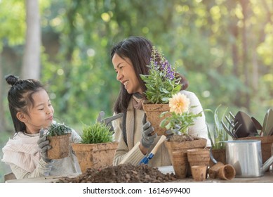 Planting Flowers. Cute Child Girl Helping Her Mother To Care For Plants. Mom And Her Daughter Engaging In Gardening At Home. Happy Family In Winter Day. Concept World Environment Day. Ecology.