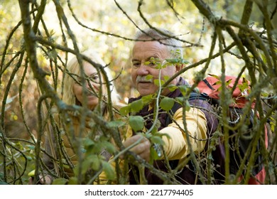 Plants And Mature Hikers Observing Them In The Forest