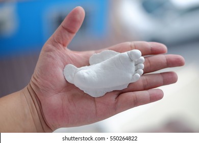 Plaster Baby Feet On Hand