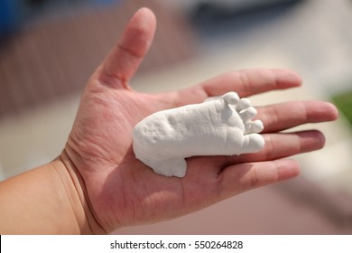 Plaster Baby Feet On Hand