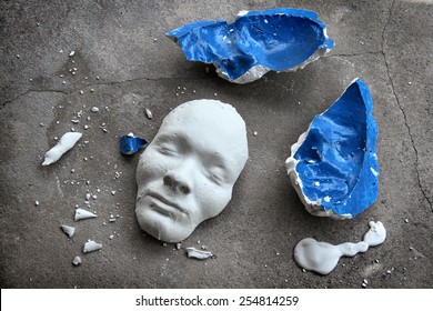 Plaster face mask between pieces of broken matt - Powered by Shutterstock