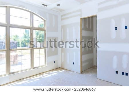 Plaster has been applied to interior walls ceiling of new house and is ready for paint priming.