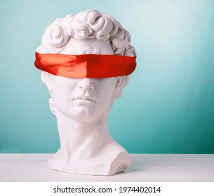 Plaster head with eyes covered red satin ribbon on blue background. Avoid problems concept.