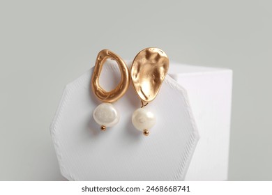 Plaster podiums with beautiful earrings on white background