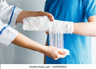 Plastered Arm, A Broken Arm At The Teenager. A Nurse Bandages A Guy's Hand