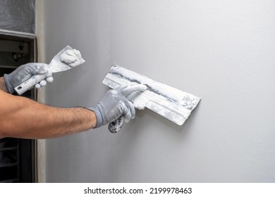Plasterer applies plaster on the wall during repair and restoration work. Leveling the wall with a spatula. 