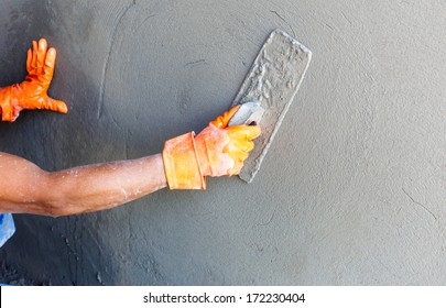 Plasterer Concrete Worker At Wall Of House Construction 