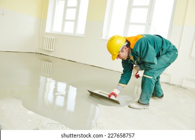 plasterer during floor covering works with self-levelling cement mortar - Shutterstock ID 227658757