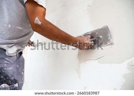Plasterer plastering the facade of a new building