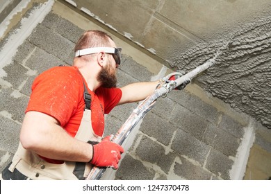 Plasterer Using Sprayer Machine Putting Plaster Mortar On Ceiling